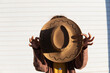 © VISTA by Westend61 - Young woman hiding behind cowboy hat on sunny day
