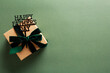 Gift box with Happy Fathers Day topper on dark green background.