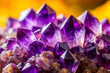 Macro of Amethyst Crystals Against Bright Yellow Backdrop
