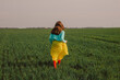 © VISTA by Westend61 - Young woman wearing yellow skirt and running on green wheat field under sky