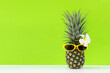 Summer in the party.  Hipster Pineapple Fashion in sunglass bright beautiful color in holiday, Creative art fruit  green background.  Fashion Summer Vacation Concept, copy space for text