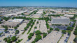 Northwest Dallas business park with ample parking spaces, group of office buildings, hotels, restaurants in Love Field neighborhood with mid-town buildings skylines background, aerial view