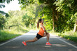 Healthy woman warming up before jogging run and relax stretching her arms and looking away in the road outdoor. Asian runner people workout fitness session, nature park background