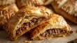 Baked pastry with meat and cheese on a wooden background. Selective focus