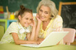 Portrait of a grandmother and daughter using laptop