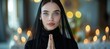 Serene caucasian nun in black habit deeply engaged in prayer inside the peaceful church