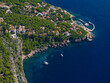 AERIAL: Anchored yachts rest in the tranquil turquoise waters of a secluded bay.