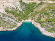 AERIAL: Scenic drone shot of a hidden gem of a sandy beach with turquoise water