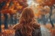 © Nena Ai - A woman with long blonde hair is walking contemplatively through a park in the golden autumn season