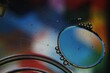 Burbujas de agua y aceite flotan en la superficie líquida, forman esferas grandes y pequeñas coloridas por refracción, original diseño abstracto para fondos.