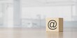 Wooden e-mail symbol on office background