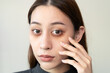 lack of sleep problem,  Worried Asian young woman pointing finger at dark circles under her eyes