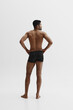 © master1305 - Back view. Young African-American man with relief strong back, muscular body standing in black boxers isolated on white background. Concept of male beauty, sport, body care, health, fitness