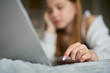 Close Up Teenage Girl With Painted Nails Lying On Bed At Home Using Laptop
