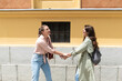 Two excited happy hipster cool women walking together on the street. High Fashion amazed model woman posing in city street. Happy leisure, carefree weekend and romantic holiday, stylish fashionable.