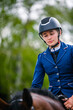 Portrait of a beautiful young woman preparing before a horse riding competition