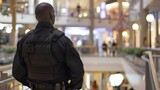 Fototapeta Sport - Security Guard in Black Stands Vigilant at Shopping Mall. Concept Security Guard, Black Uniform, Vigilant, Shopping Mall, Authority Figure