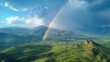 Rainbow, the time when the rain stops falling. Wide angle view of mountains, sunlight, and clouds.