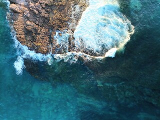 Wall Mural - Aerial view of a wave hitting a reef in Shellharbour.