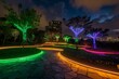 the pathway at the park is lit with colorful lights from led trees