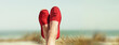 Damenbeine mit Roten Stoffschuhen am Strand