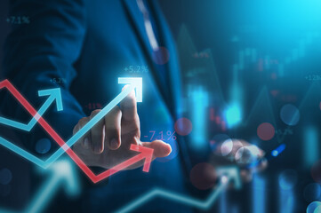 Fototapete - Investing and stock market concept. A businessman focuses the data growth arrow and analyses the profit with financial exchange and digital money growth.