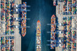 Aerial top down view of a large container cargo ship terminal with loading activity and vessel traffic