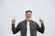 © Stock 4 You - Smiling mature 40s old grey haired businessman in casual clothes, pointing up above head both hands at copy space for promo advertising. Businessman standing isolated, white background, looking camera