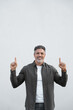 © Stock 4 You - Smiling mature 40s old grey haired businessman pointing up above head both hands at copy space for promo advertising. Hispanic businessman standing isolated, white background, looking camera. Vertical