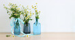 spring bouquet of daisies flowers over wooden table and white patel background