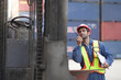 © Montri - Engineer or Caucasian man worker working in container port terminal. import and export container. logistic engineer man worker or foreman working forklift container at container site.