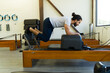 Man exercising on pilates reformer machine