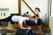 Pilates instructor guiding client on reformer bed