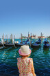 Little girl is watching the gondolas of the Grand Canal on a sunny day in Venice, Italy. San Giorgio Maggiore. Poster.