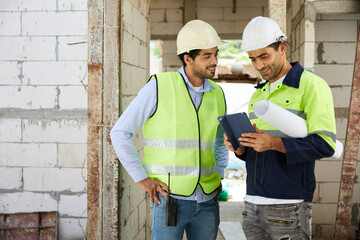 workers or architects meeting and working on tablet at construction site