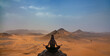 Woman in yoga position with the desert in the background