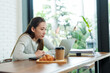 © Ekkasit A Siam - Beautiful Asian woman small business owner A barista is sitting at a table in a coffee shop. After stressing over checking the store's accounts Drink coffee in afternoon to keep from feeling sleepy.