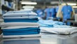 Stack of clean sheets, surgical clothes, and iron in industrial laundry setting on white background