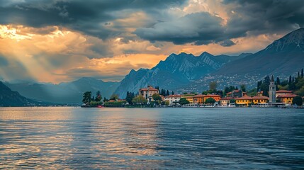 a lake with a mountain range in the background and a town on the shore with a church on it..