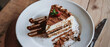 White plate with a piece of delicious tiramisu cake