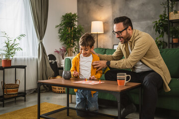 Father and son play board game together at home