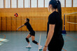 Diverse female volleyball players practicing volleyball at indoor court