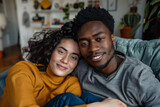 Fototapeta  - Multi-ethnic couple at home on the sofa in an embrace
