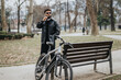 © qunica.com - A business entrepreneur enjoying a relaxing moment in a tranquil park setting with his bicycle.
