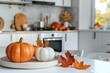 Modern white kitchen decorated with orange fall pumpkins