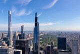 Fototapeta Góry - Vibrant urban skyline with towering skyscrapers and impressive architecture seen from Top of The Rock in New York. View on the Central Park from above. Hudson river on the side. Modern and lively city