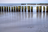 Fototapeta  - A series of wooden breakwaters and a pier on a sandy beach on the island of Wolin