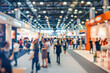 © Visual Craft - People walking at modern expo, indoor fair exhibition crowd, with bokeh
