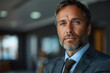 © Gonzalo - Portrait of successful mature boss, senior businessman in glasses and business suit looking at camera and smiling, man with crossed arms working inside modern office building