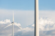 A wind turbine is standing next to a tall pole